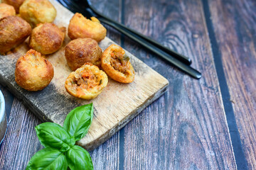 Mini cheese  burger balls.  Ball shaped snack with meat, pickled cucumbers and tomato on wooden...
