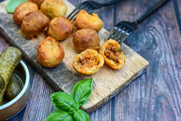 Mini cheese  burger balls.  Ball sЧhaped snack with meat, pickled cucumbers and tomato on wooden background