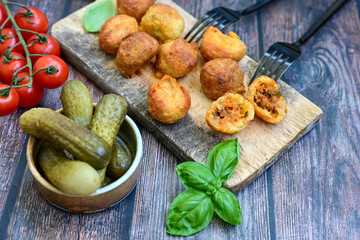 Mini cheese  burger balls.  Ball sЧhaped snack with meat, pickled cucumbers and tomato on wooden background
