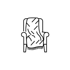 A cozy armchair with a blanket with a minimalist line drawing.