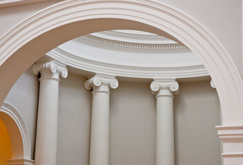 Arches and columns looking through an intimate view of architectural details of a building interior with ionic capitals atop smoothly rounded columns_20101218_05576