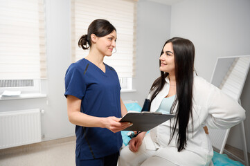 Pregnant woman undergoing examination in medical office. Female doctor consulting pregnant woman....