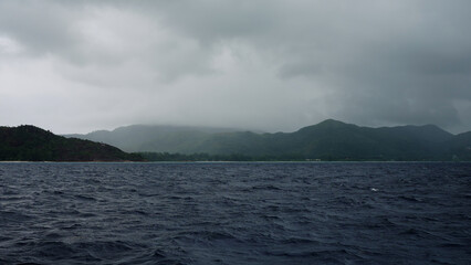 Sailing on a boat around Seychelles island on a foggy day