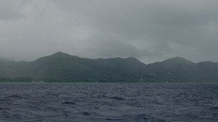 Sailing on a boat around Seychelles island on a foggy day