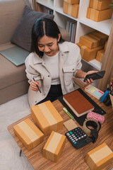 an entrepreneur is packing parcel for order from customer, she own a small business, sme, a lot of...