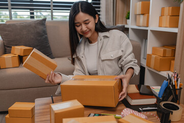 she is packing parcel to send to all customers, this entrepreneur own a small business, sme,...