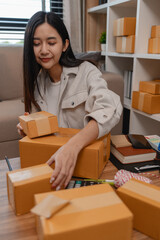 she is packing parcel to send to all customers, this entrepreneur own a small business, sme, selling product online, she prepare her product in her office, packing order