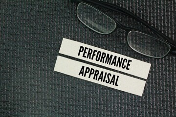 Glasses and paper with the words performance appraisal. a structured process used by organizations...