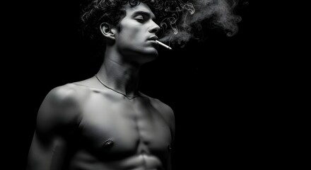 Young man with curly hair smoking cigarette, smoke exhaling on black background. Smoking addiction, health risk concept.
