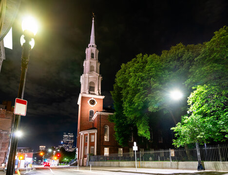 Park Street Church in Boston, Massachusetts, United States stands brightly lit at a quiet downtown intersection