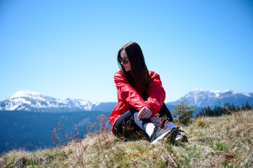 Female sitting on the hill of high mountains enjoying summer nature scenery. A girl siting on the...