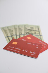 Credit cards and dollar bills on white background. a blue plastic bank card is lying on a pile of American dollars. Payment by credit card