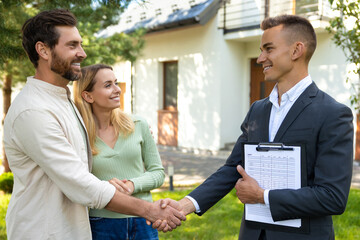 Family meeting realtor for house deal in front of modern property