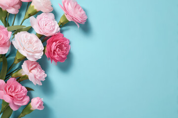 水色の背景に配置されたピンクのカーネーションの花束
