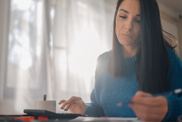 Focused accountant managing budget and calculating expenses at home office