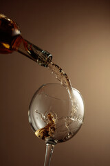 Pouring white wine from a bottle into a glass.