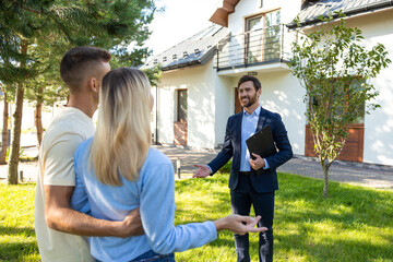 Real state agent giving the key from a new house to the clients
