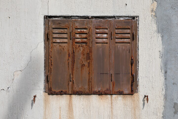 old steel rusty closed shutters on home facade