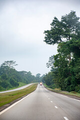 Naklejka premium Ivorian highway crossing the rainforest under a misty sky