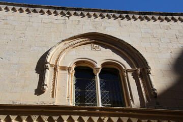 Historic double arch window on a facade in an alley of Mdina, Malta  
