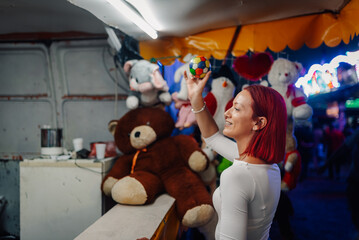 Woman throwing ball at carnival game trying to win prize