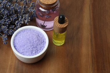 Lavender and lavender oil in bottles on wooden background

