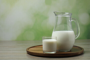 glass and jug with milk on wooden background
