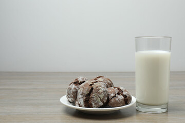 glass with milk and cookies on wooden background