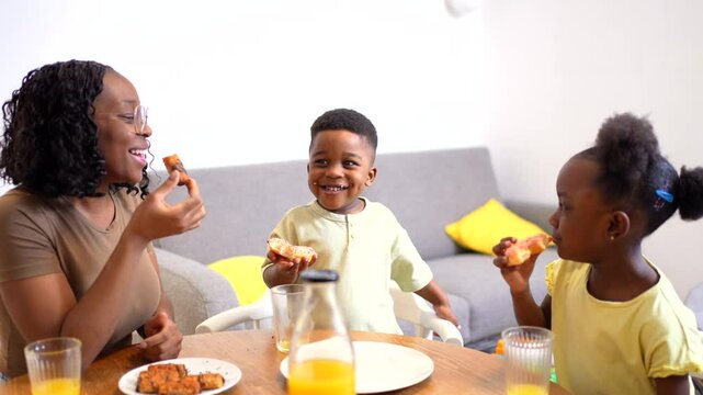 African american mother enjoying breakfast with her children, sharing food and laughter in a warm and loving atmosphere