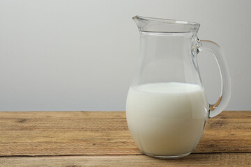 jug of milk, cornflakes on wooden background