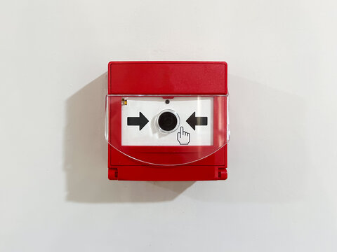 Red fire alarm button on white wall for safety emergencies.