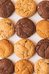 Pattern of Assorted Cookies on Yellow Background, Mixed Cookies Flat Lay with Bold Yellow Background, Cookies in Perfect Order – Minimalist Food Photography, Rows of Chocolate Chip and Cocoa Cookies