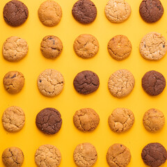 Pattern of Assorted Cookies on Yellow Background, Top View of Chocolate and Vanilla Cookies Arranged in Rows,  Colorful Cookie Grid on Bright Yellow Backdrop, Cookies in Perfect Order – Minimalist Foo