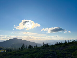 Scenic mountain landscape with clouds and blue sky at sunset.
