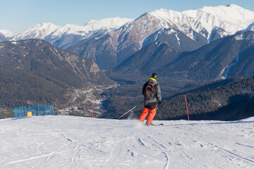 Skiers, snowboarders skiing in a mountain resort