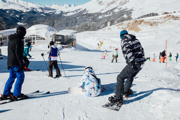 Snowboarders and skiers ski in the resort on the slopes