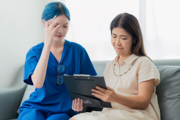 An elderly Asian woman visits the doctor and talks to the doctor about her illness in the clinic.