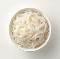 A white bowl filled with a generous portion of cooked, thin, white rice noodles sits on a plain white background; viewed from directly overhead