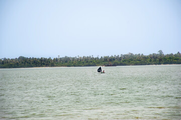Black-sailed pirogue on the Abidjan lagoon – Tropical nature and peaceful horizon