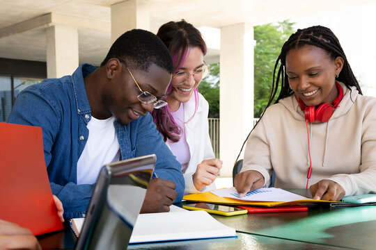 Three students working together on an outdoor assignment