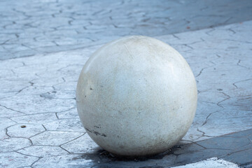 concrete sphere or ball bollard installed on pedestrian sidewalk in urban environment