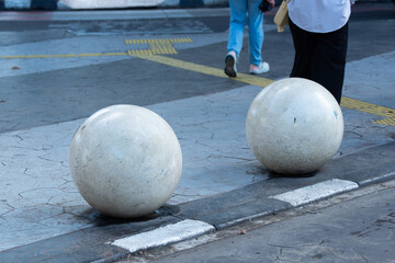 concrete sphere or ball bollard installed on pedestrian sidewalk in urban environment