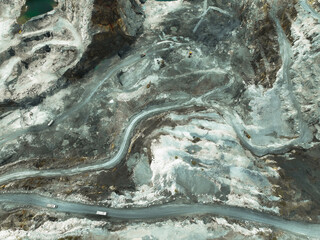 Open pit mine. Limestone granite quarry. Terraced mining levels with winding access roads and heavy...