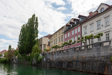 A picturesque view of the charming Ljubljanica River flowing through Ljubljana. The riverbank is...