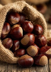 Rustic burlap sack overflowing with glossy fresh chestnuts on weathered wooden surface, warm natural tones, perfect for autumn harvest, organic food, countryside or seasonal rustic concepts.
