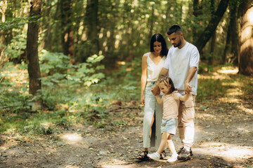 Happy Family Strolling Together Through a Peaceful Forest Path in Summer