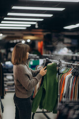 Woman Using Steamer to Smooth Clothes in a Store Setting