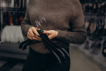 Close-Up of Woman Holding Clothing Hangers in a Retail Environment