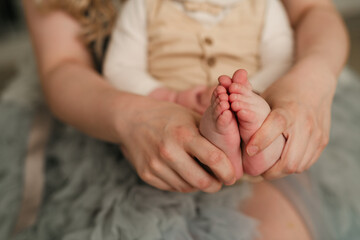 mother's hands holding baby's feet. tiny details full of motherly love and connection
