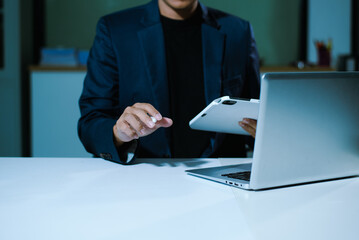 Businessman using on smartphone and tablet and laptop at office